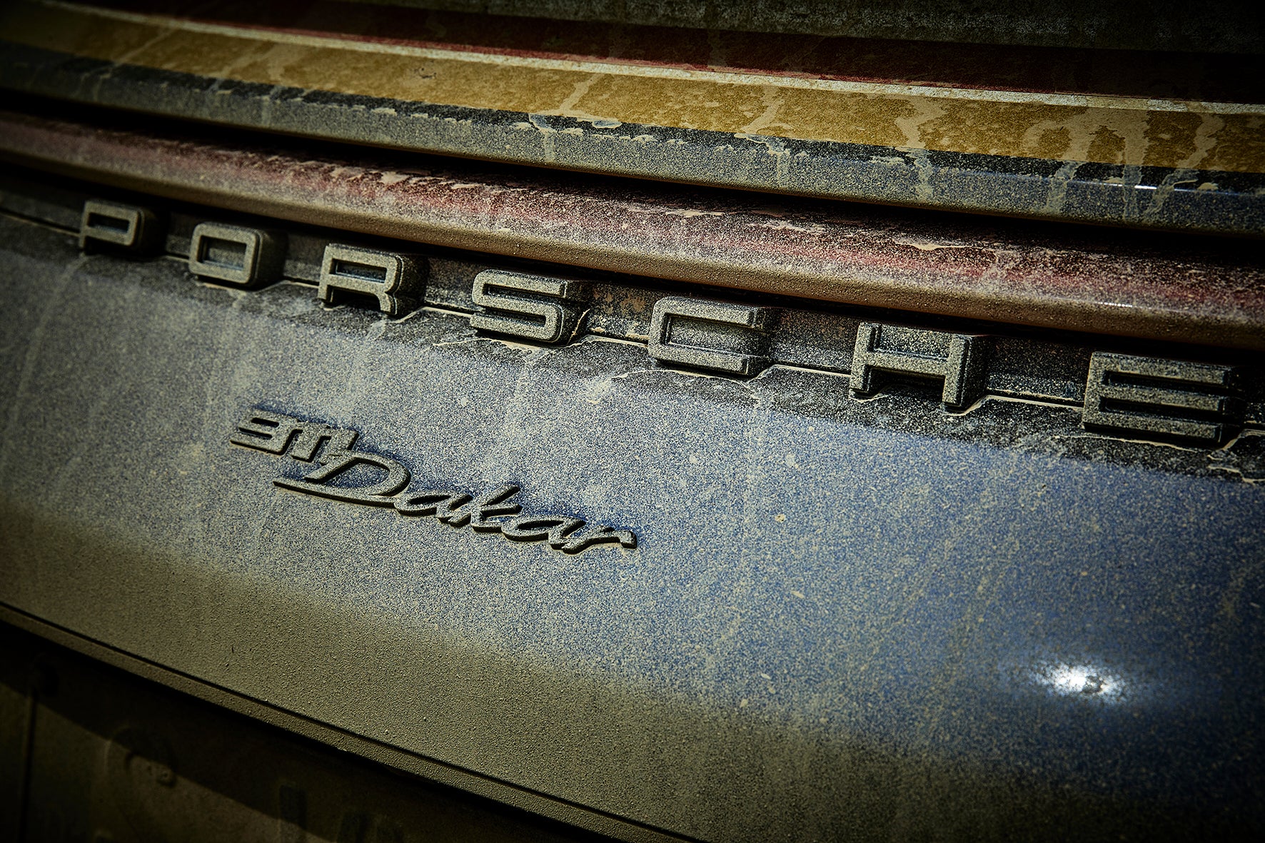 Fine art photograph by Frank Kayser – close-up of Porsche 911 Dakar rear, sandy and dusty textures.