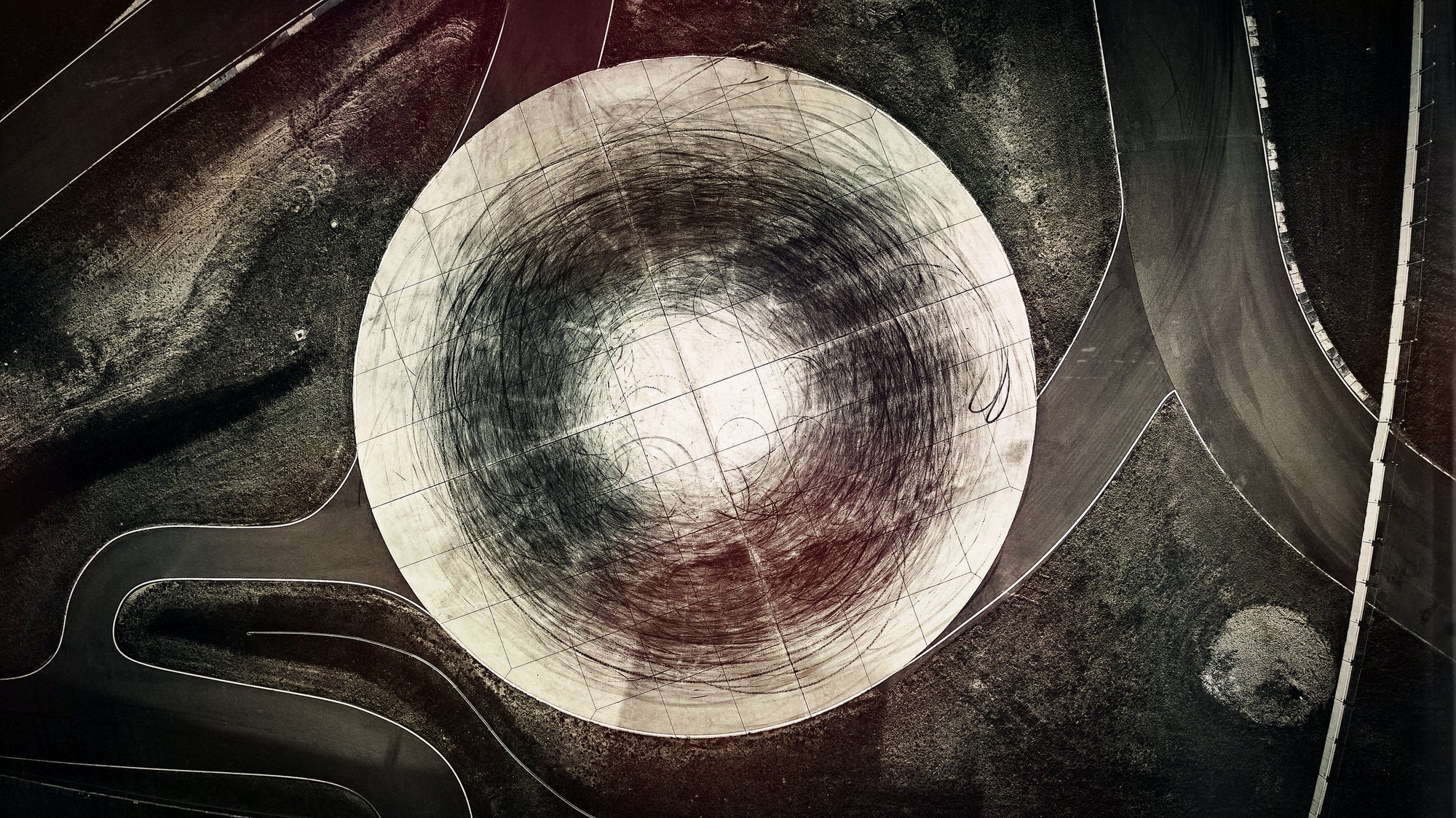 Fine art aerial photo by Frank Kayser – skid marks form a perfect circular pattern on asphalt.