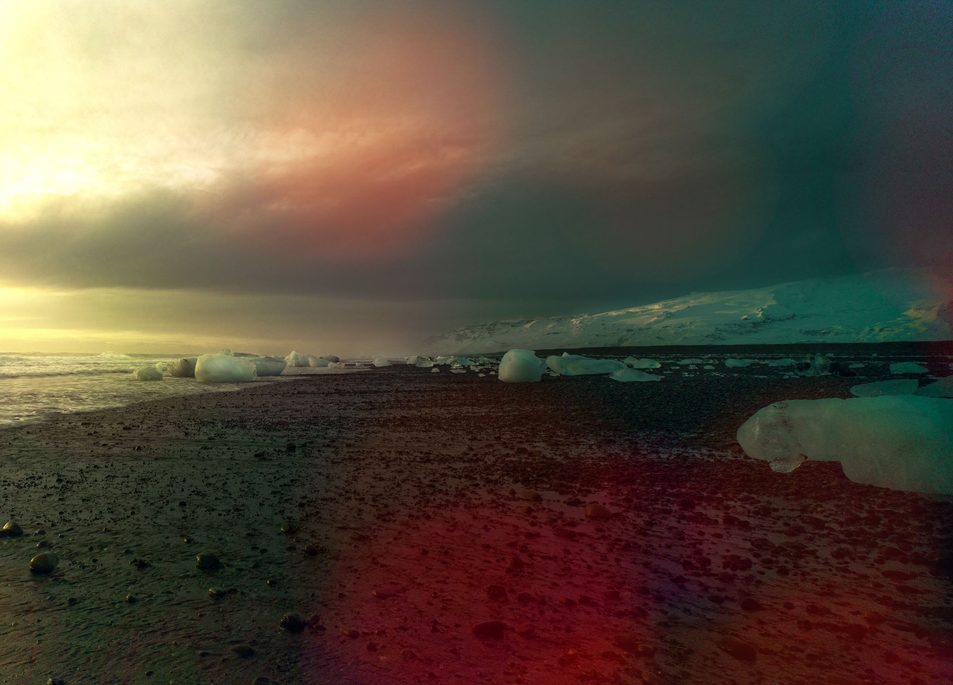 Landscape photograph of Icelandic coast with ice blocks and dramatic polar sky.