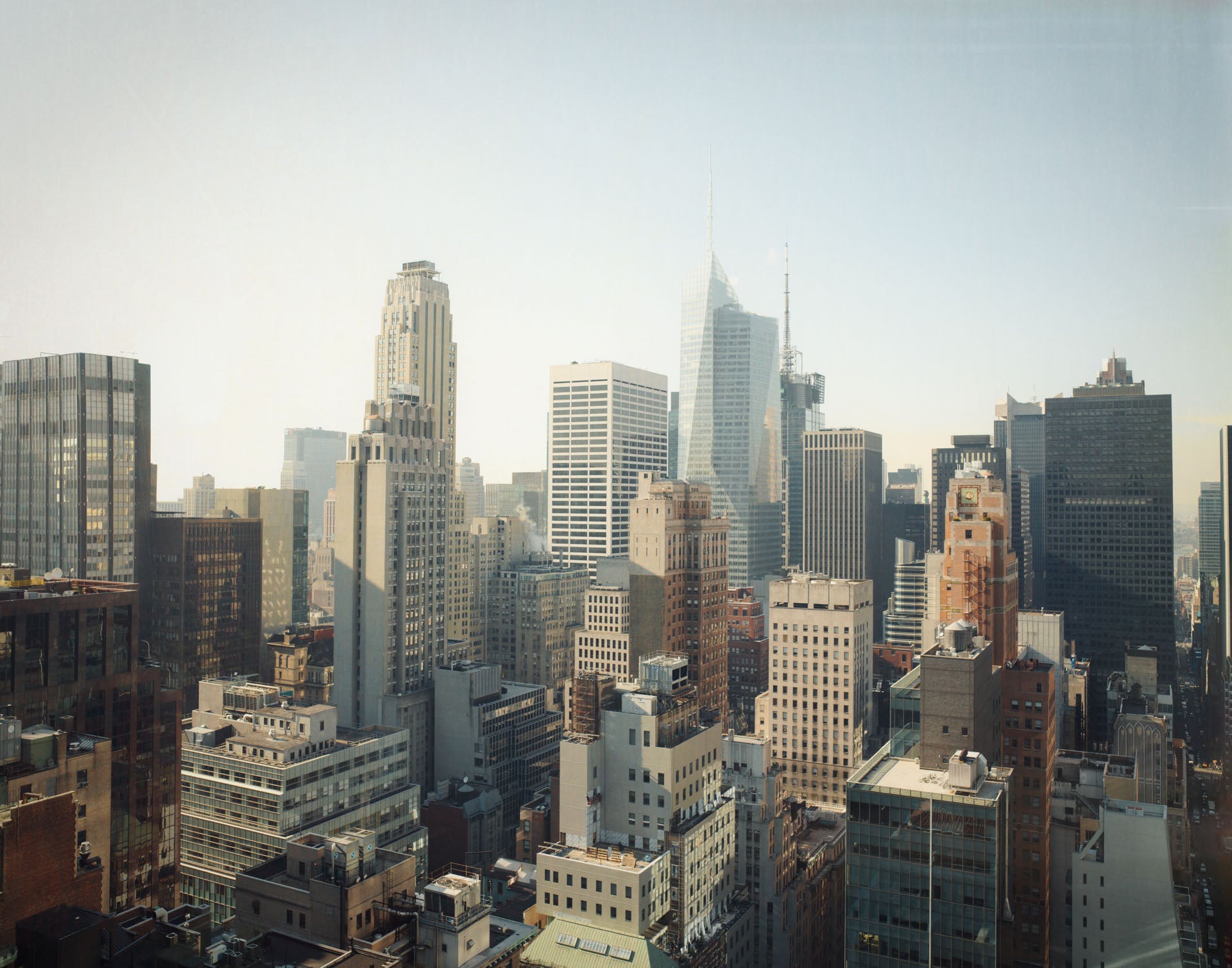 Skyline photograph of New York City in soft daylight, reminiscent of the 1960s.