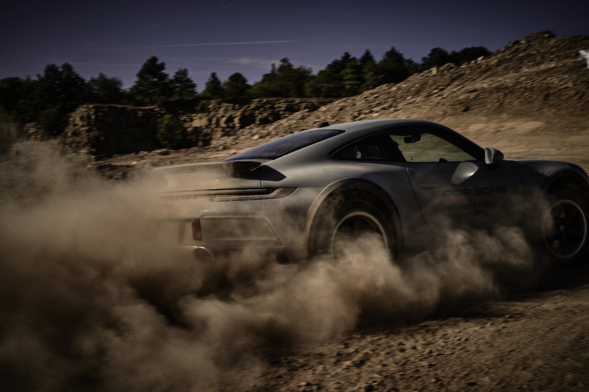 Fine art photography by Frank Kayser – Porsche 911 Dakar drifting tightly in dust, rear view under dramatic light.
