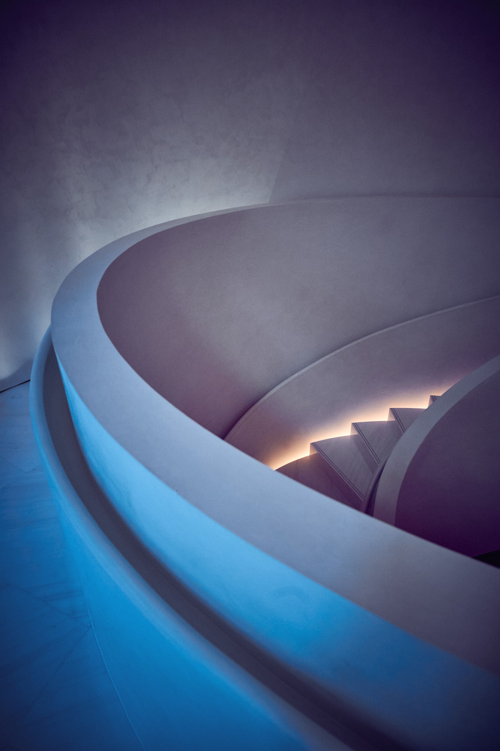 Fine art architectural photography by Frank Kayser – soft spiral staircase with glowing steps and curved minimalistic lines, poetic architectural wall art, limited edition print.