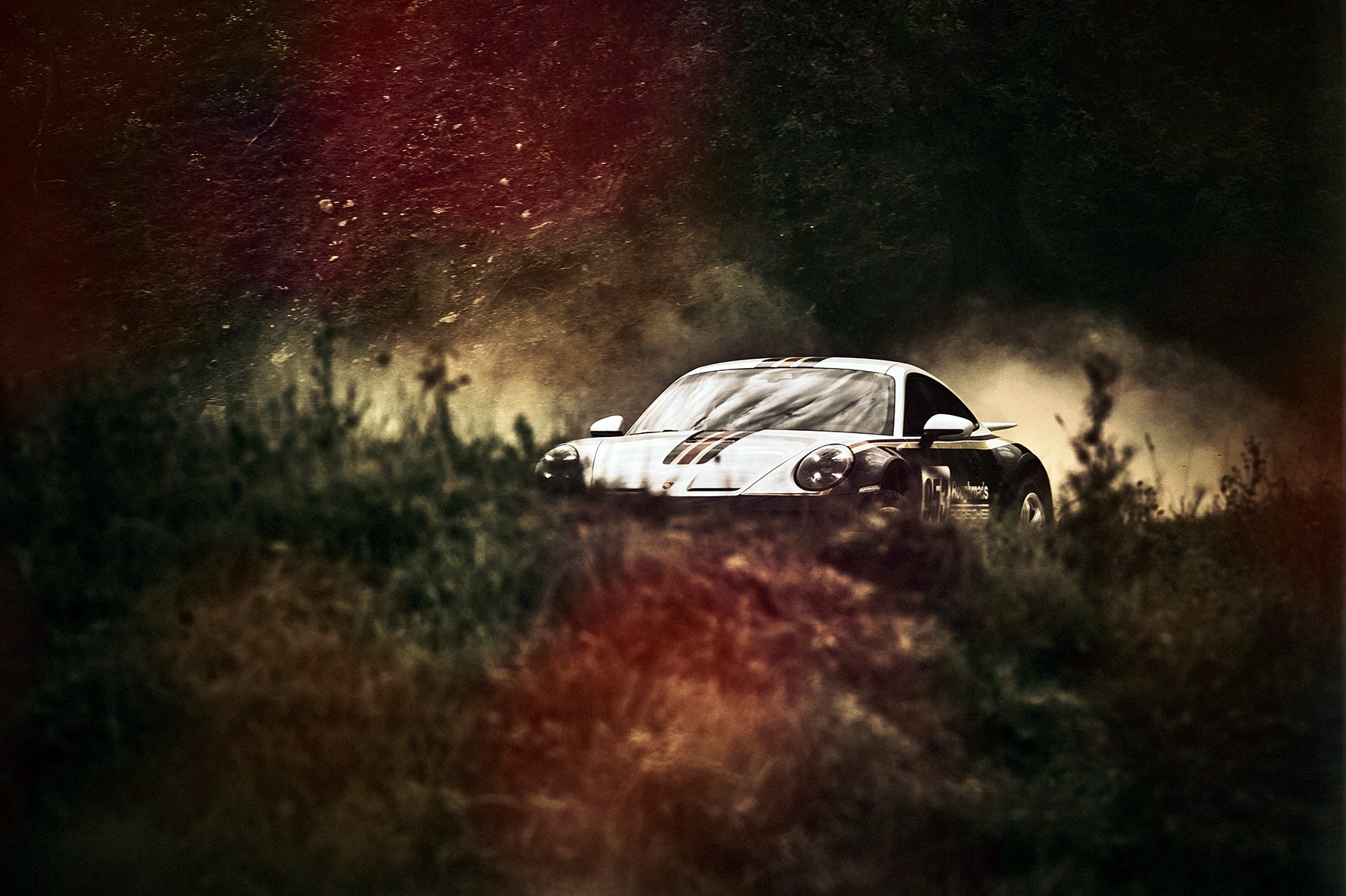 Fine art photo of Porsche 911 Dakar emerging from shadows, panther-like presence on the rally track.