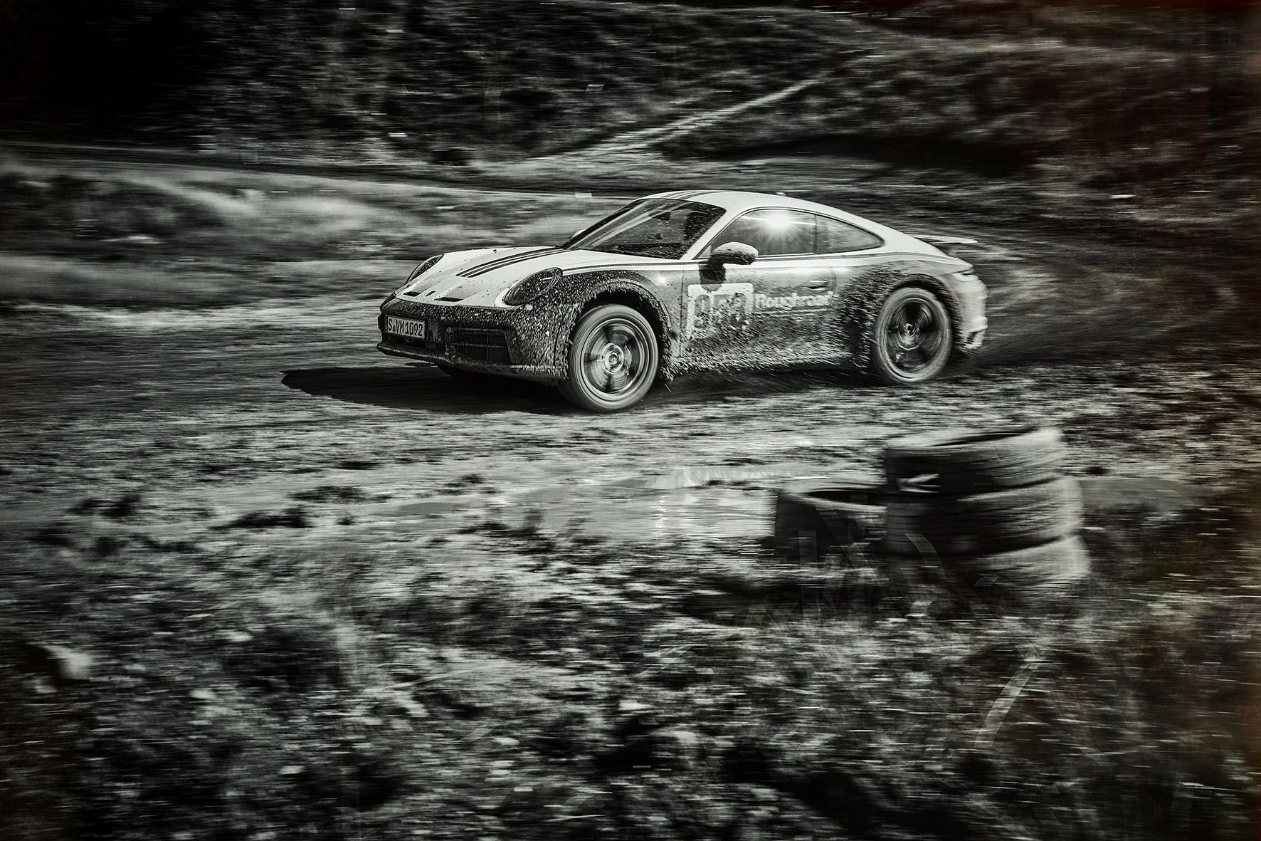 Fine art photograph by Frank Kayser – Porsche 911 Dakar racing through mud, tires spinning with force.