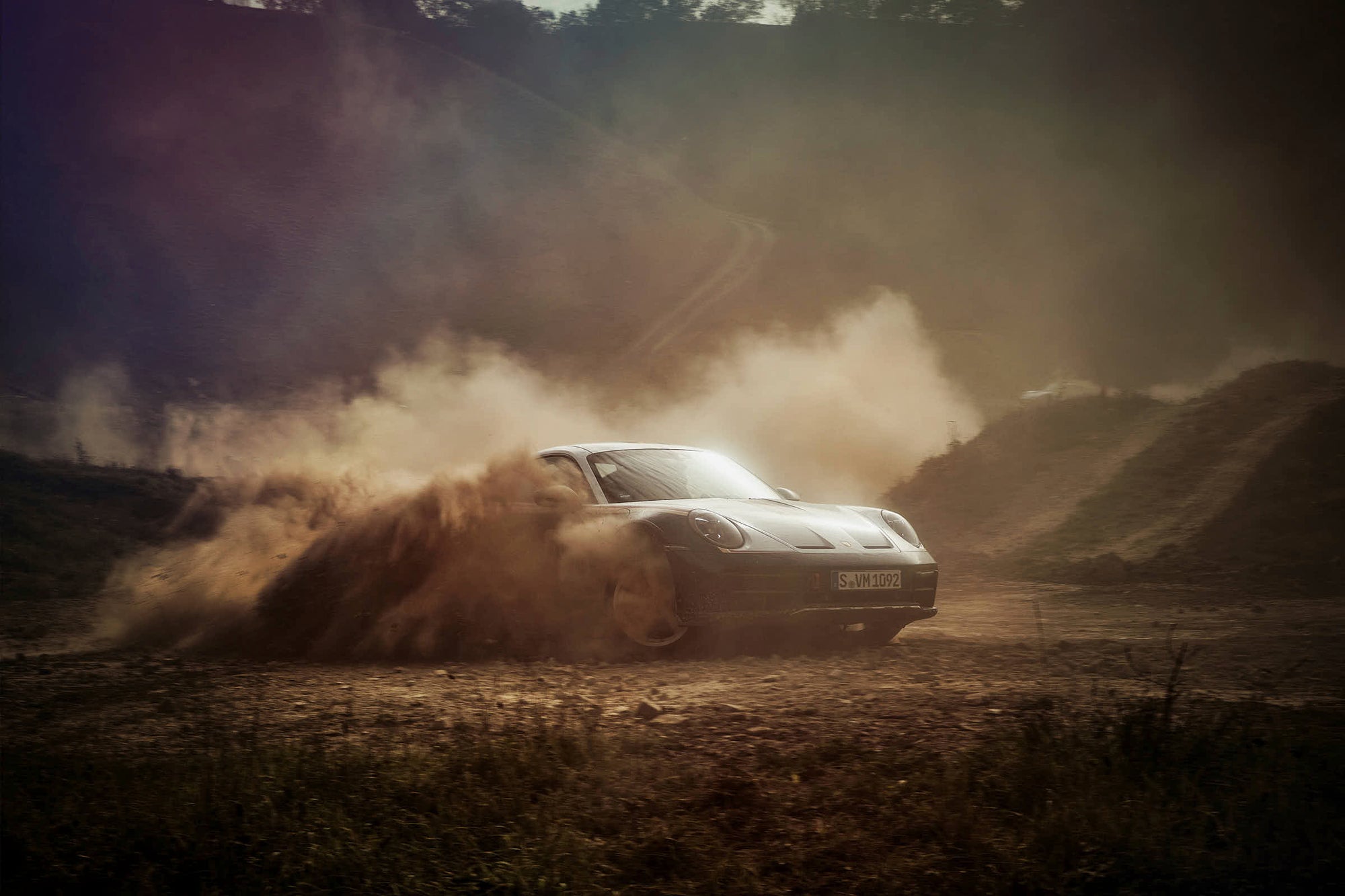 Fine art photography by Frank Kayser – Porsche 911 Dakar cutting through the dust in golden sunlight, dramatic rally scene.