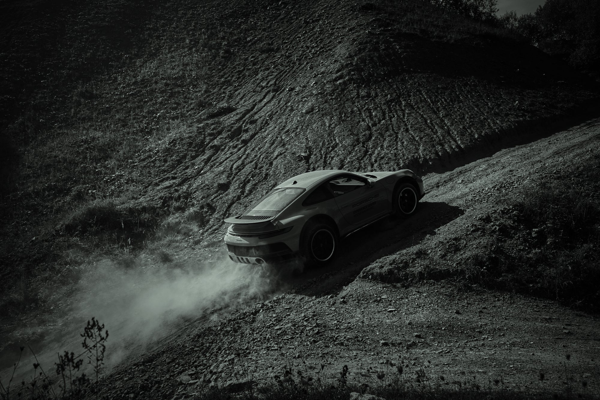 Fine art photography by Frank Kayser – Porsche 911 Dakar climbing a steep gravel hill in dramatic black-and-white tones.