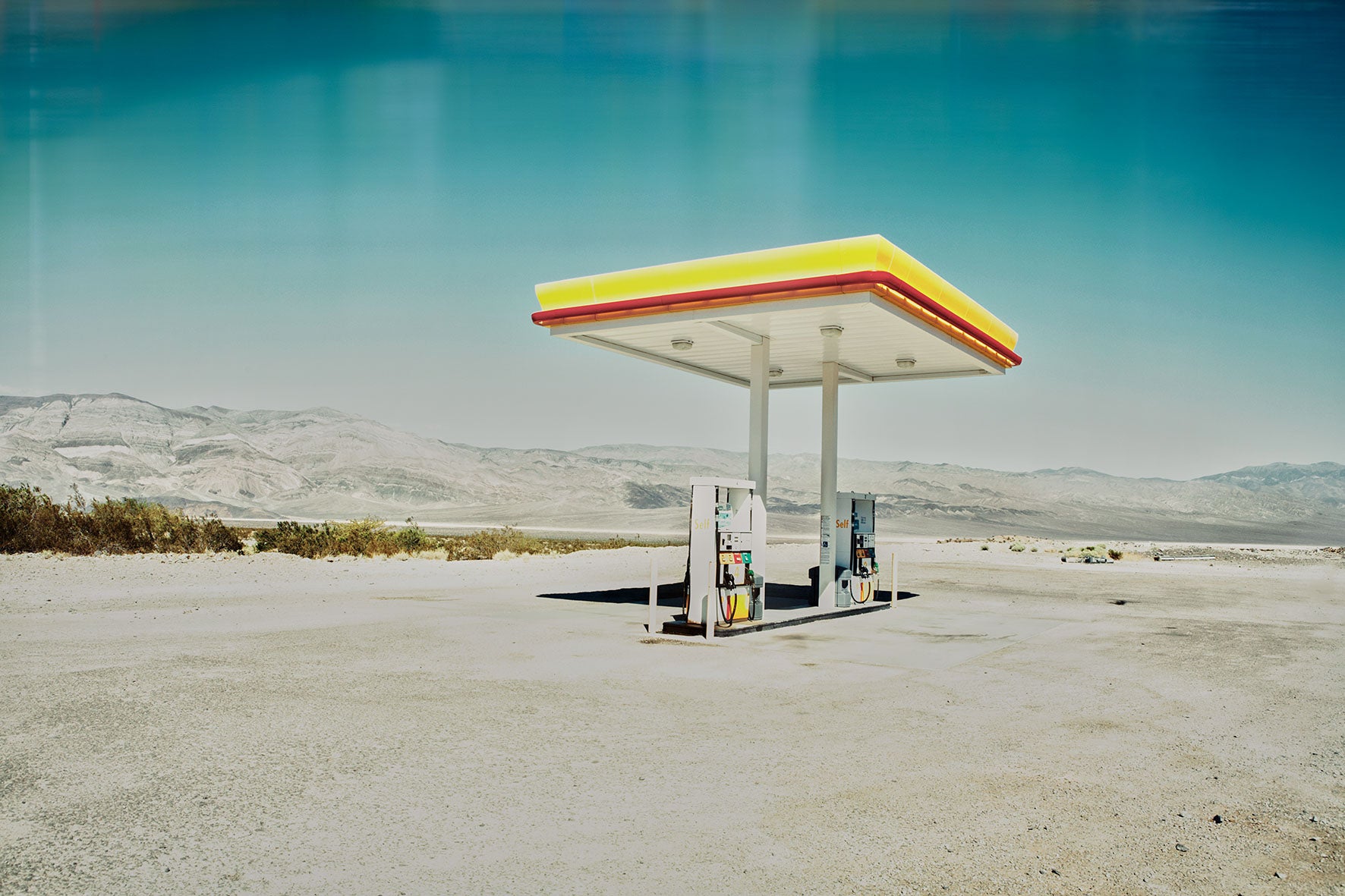 Fine art photograph of a lonely gas station in Death Valley desert landscape.