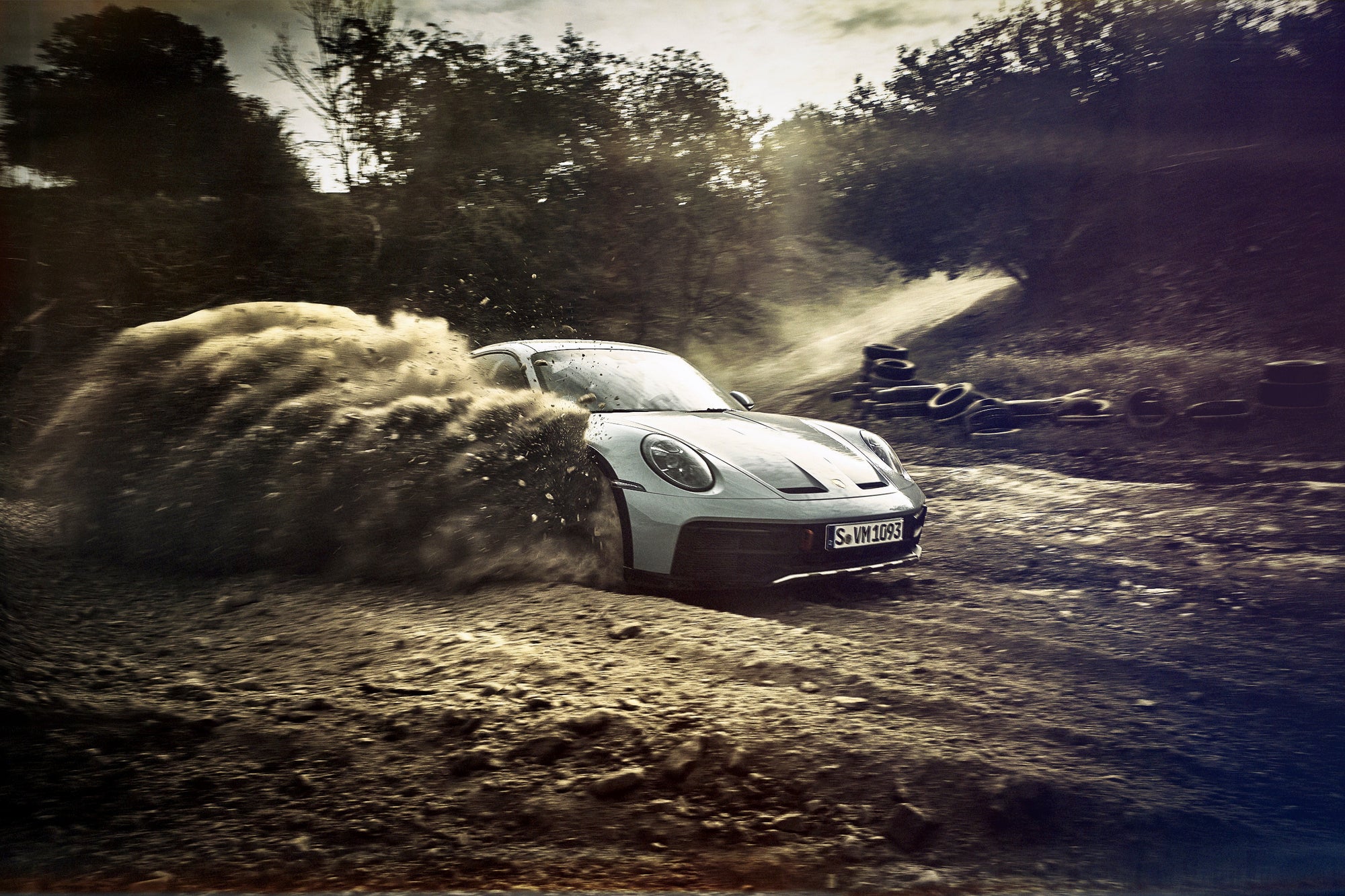Fine art photo by Frank Kayser – Porsche 911 Dakar breaking through gravel, framed by flying debris.