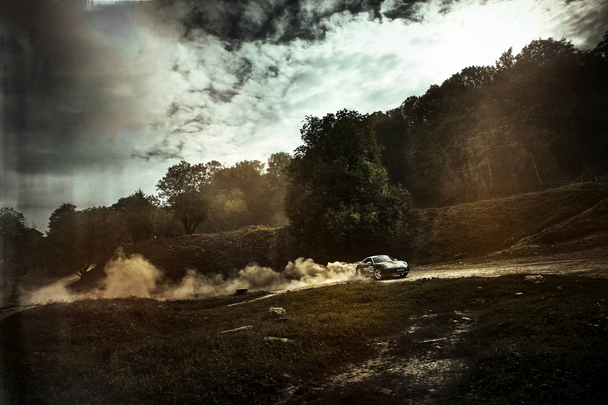 nice landscape of an offroad drifting Porsche 911 Dakar
