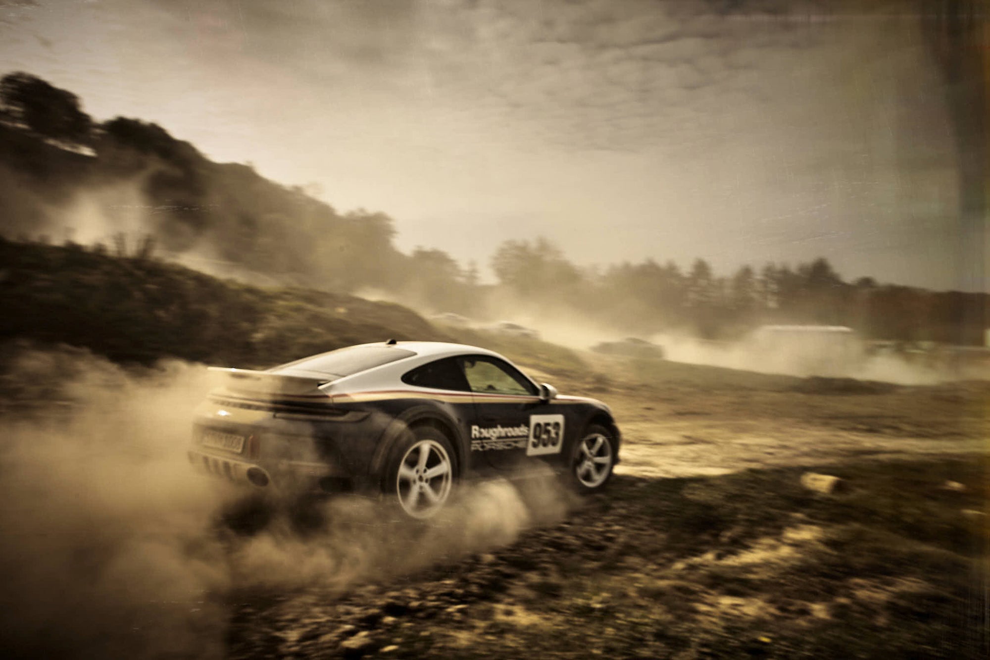 nice landscape of an offroad drifting Porsche 911 Dakar