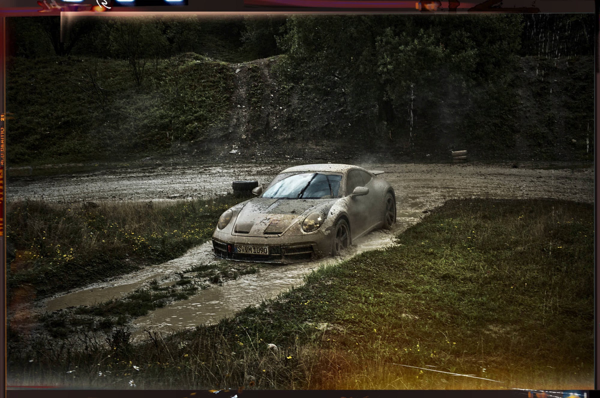 a Porsche 911 Dakar diving into muddy waters