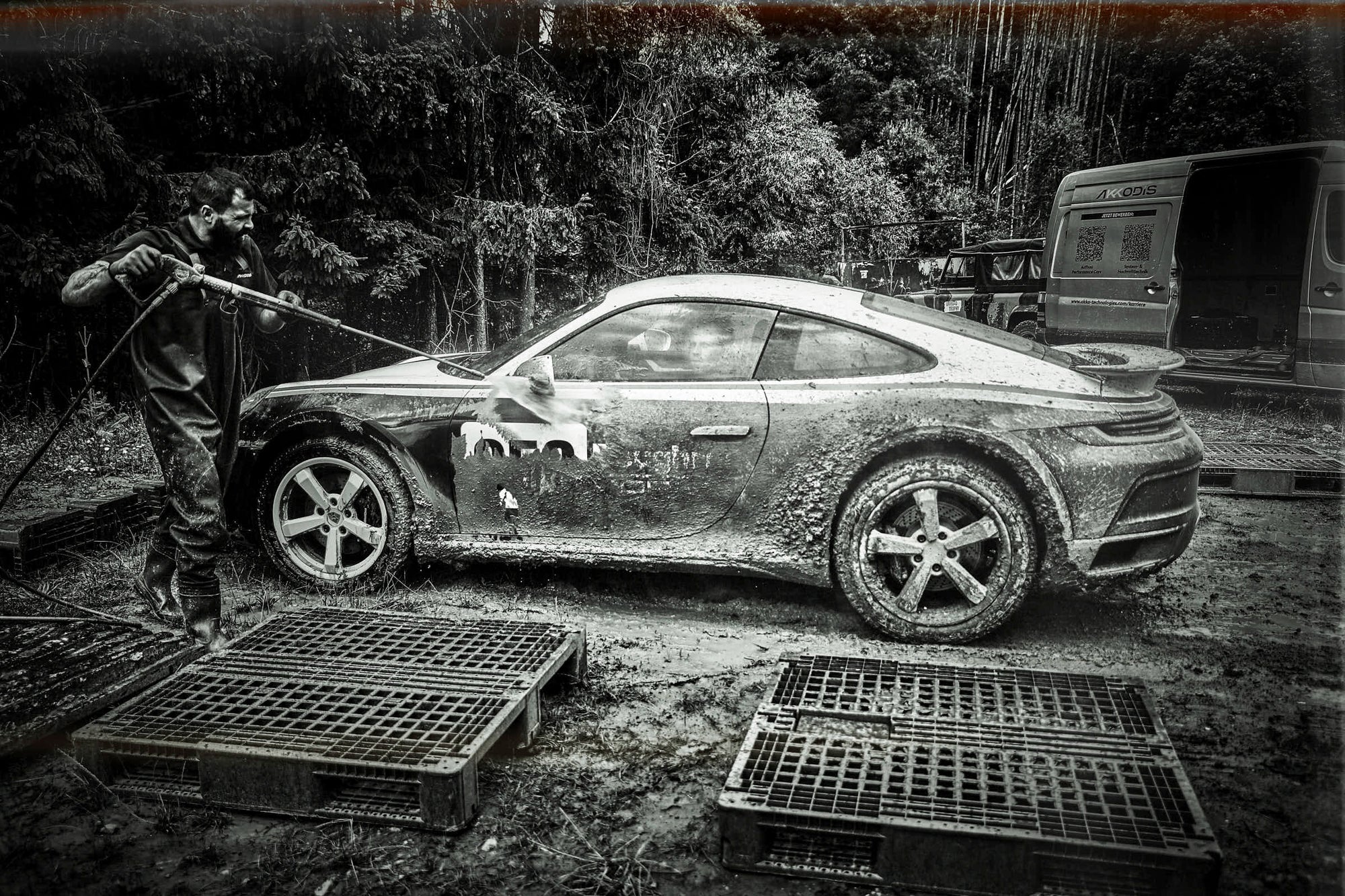 Seitenansicht beim Hochdruckreinigen eines Rallye-911, Paletten im Vordergrund.